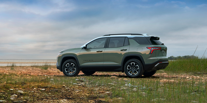 a green 2025 Chevrolet Equinox parked in a grassy field