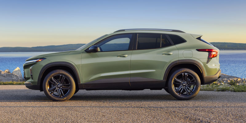a green 2025 Chevrolet Trax parked on the side of a lake